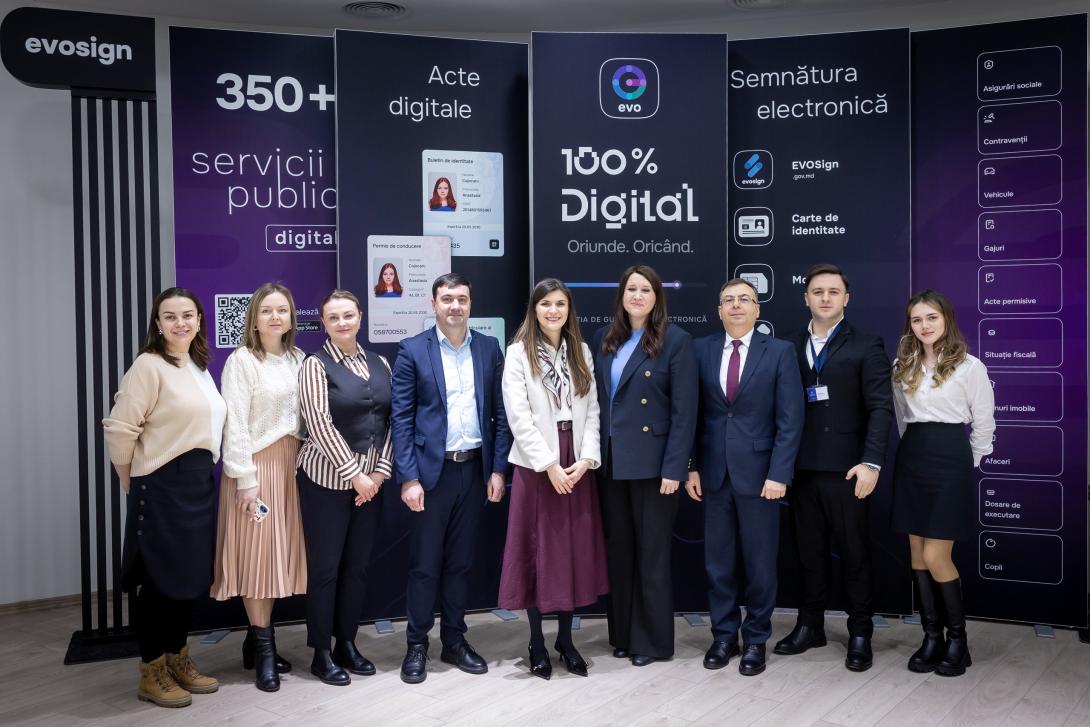 Fotografie de grup cu reprezentanții Institutului Național de Administrație și Management Public și ai Agenției de Guvernare Electronică, realizată după semnarea acordului, pe fundalul panourilor ce promovează serviciile publice digitale.